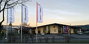Ein Lagergebäude mit Fahnen davor im Morgengrauen.